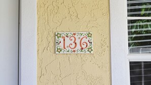 A house number plaque with floral design on a textured wall. - Hotel Room Convenient Ground-Floor Room Steps from the Beach (Bradenton Beach)