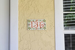 Eine Hausnummer an einer verzierten Fassade mit floralem Dekor.