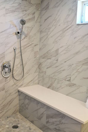 A bathroom with a shower, a sink, and a toilet.