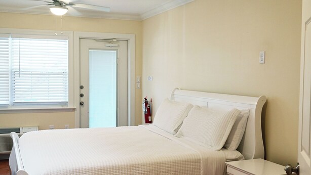 A bedroom with a bed, bedside table, and a ceiling fan. - Hotel Room Convenient Ground-Floor Room Steps from the Beach (Bradenton Beach)
