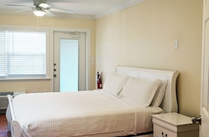 A bedroom with a bed, bedside table, and a ceiling fan.