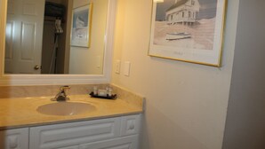 A bathroom with a sink, mirror, and framed picture on the wall. - Bright Second-Floor Studio Near the Beach (Bradenton Beach)