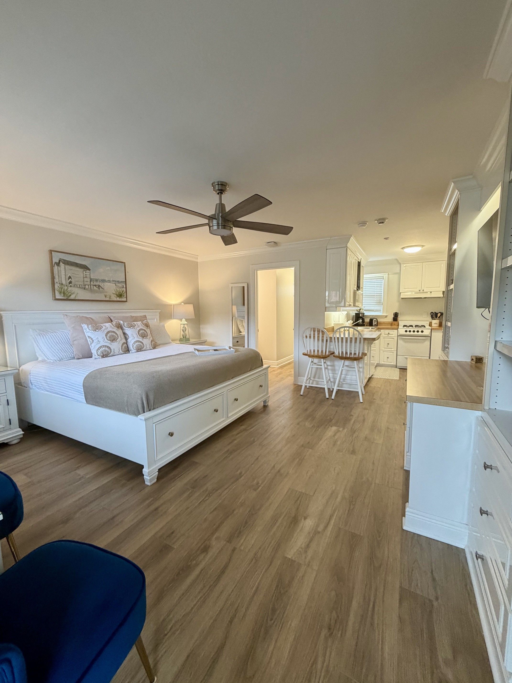 A bedroom with a bed, bedside tables, a ceiling fan, and a nightstand.