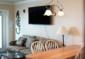 A living room with a sofa, chairs, a TV, and a lamp. - Cozy Gulf-View Studio Steps from the Beach (Bradenton Beach)