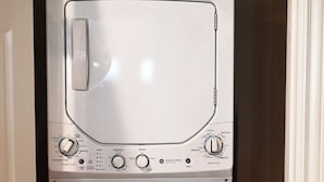 En tvättmaskin med frontmatning, försedd med kontrollpanel, vatteninlopp och avloppsslang.