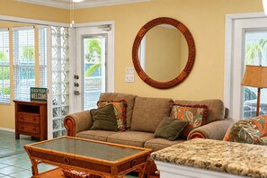 A living room with a sofa, two armchairs, a coffee table, and a large mirror on the wall. - Room to Relax · Two-Bedroom Stay on Gulf Drive (Bradenton Beach)