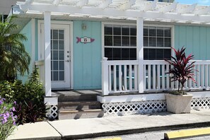 A house with a porch, a door, and a number sign.