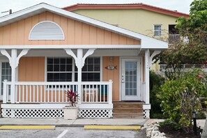 A two-story house with a porch, a mailbox, and a small garden.