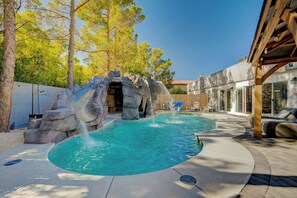 A swimming pool with a waterfall feature, surrounded by trees and a covered patio area. - Japanese Retreat (Las Vegas)