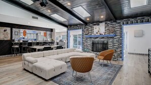 A modern living room with a sectional sofa, two armchairs, a fireplace, and a kitchen in the background. - Japanese Retreat (Las Vegas)
