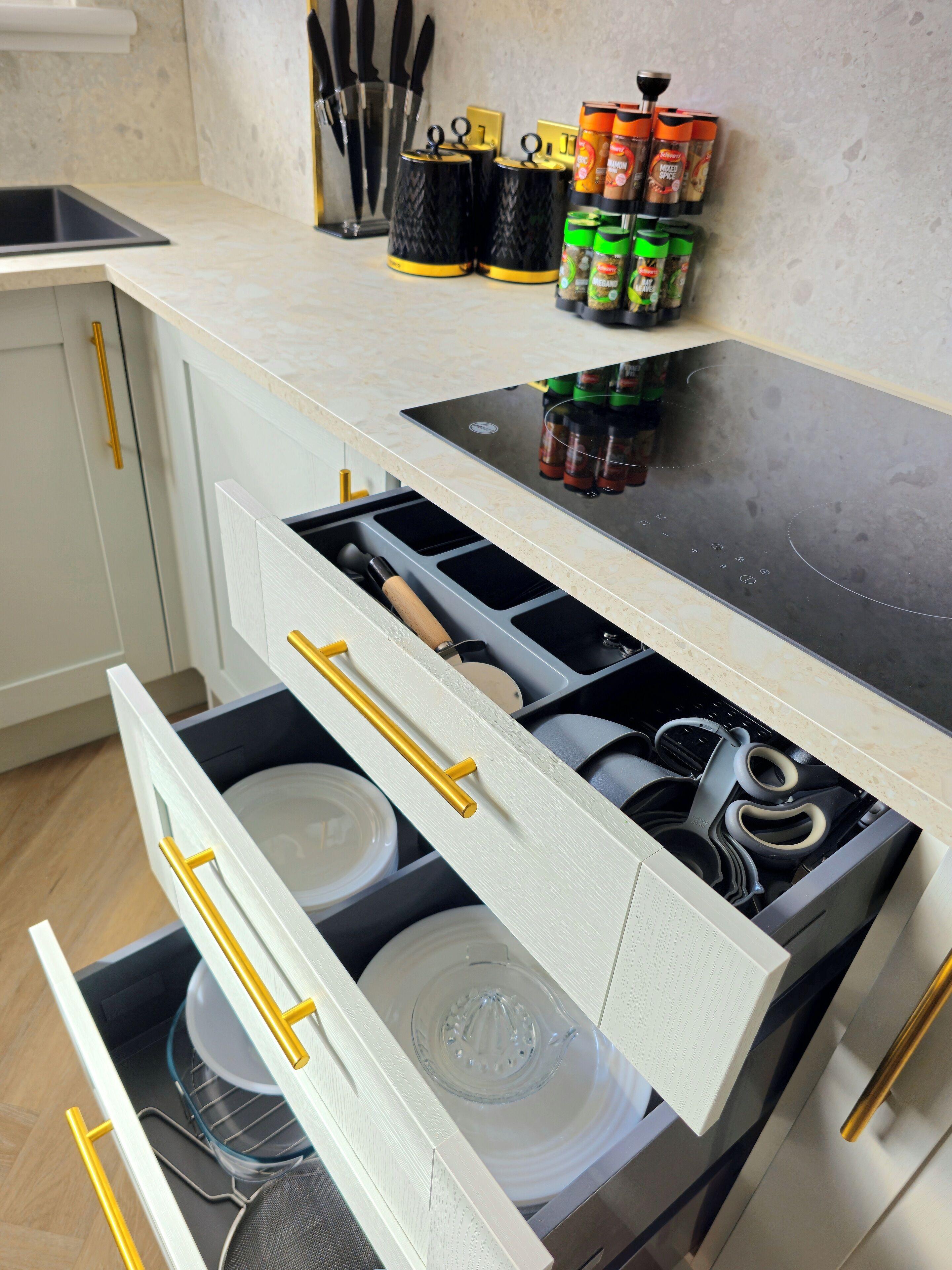 A kitchen with a built-in stove, a sink, and a countertop with various kitchen utensils and containers.