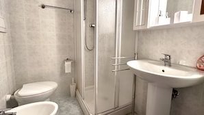 A bathroom with a toilet, bidet, and a shower enclosure. - SE097 - Senigallia, two-room apartment with garden (Senigallia)