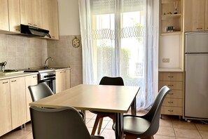 Une cuisine équipée d’une table à manger, de chaises, de placards, d’une cuisinière et d’un réfrigérateur.