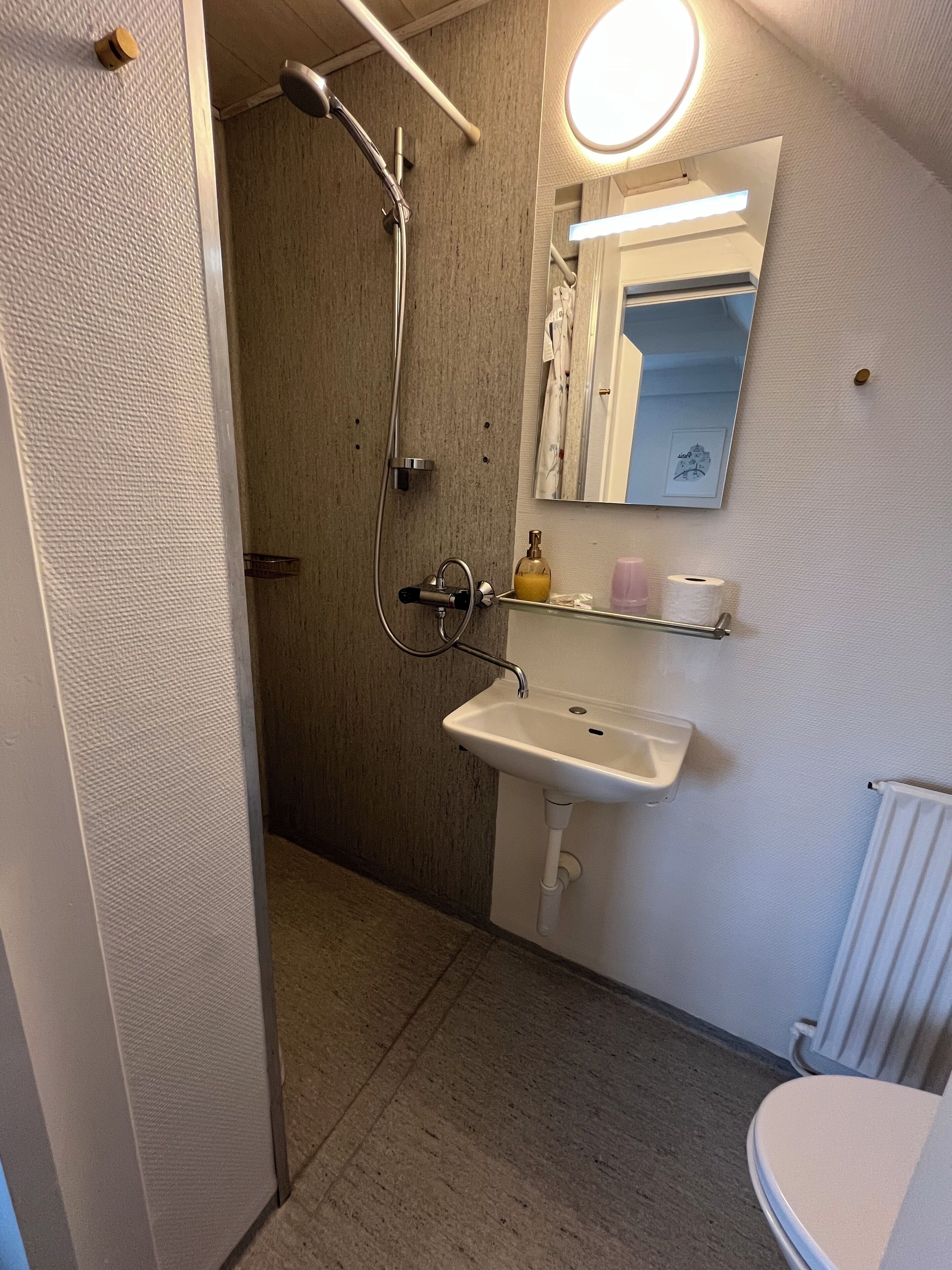 Un baño con ducha, lavabo e inodoro.