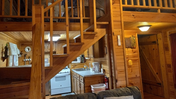 L’intérieur d’une cabane en bois comprend une cuisine, un escalier et un espace de vie.