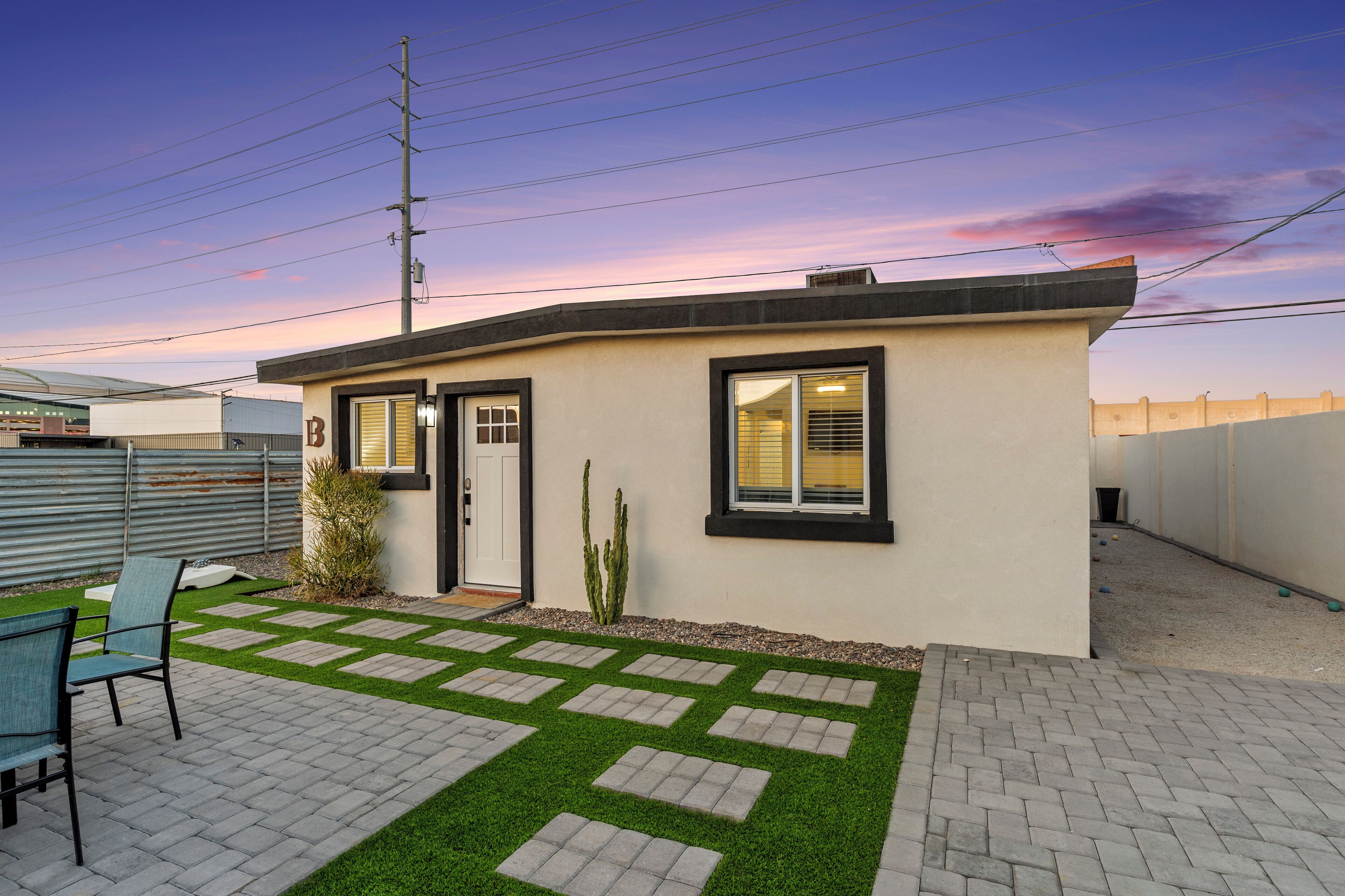 A modern house with a paved patio, a small garden, and a single door.