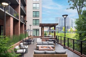 A rooftop patio with outdoor seating, a barbecue area, and a pergola.