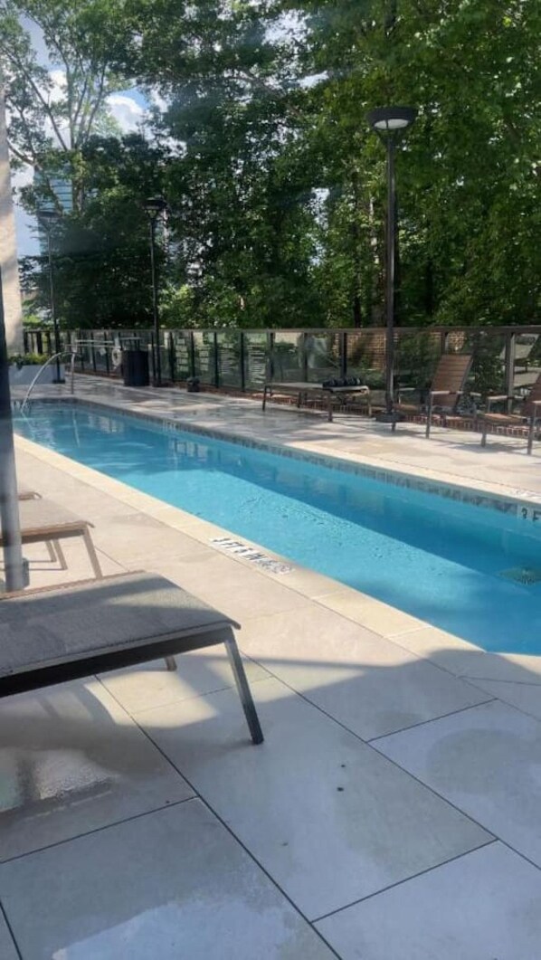 A swimming pool with lounge chairs and a lamp post.
