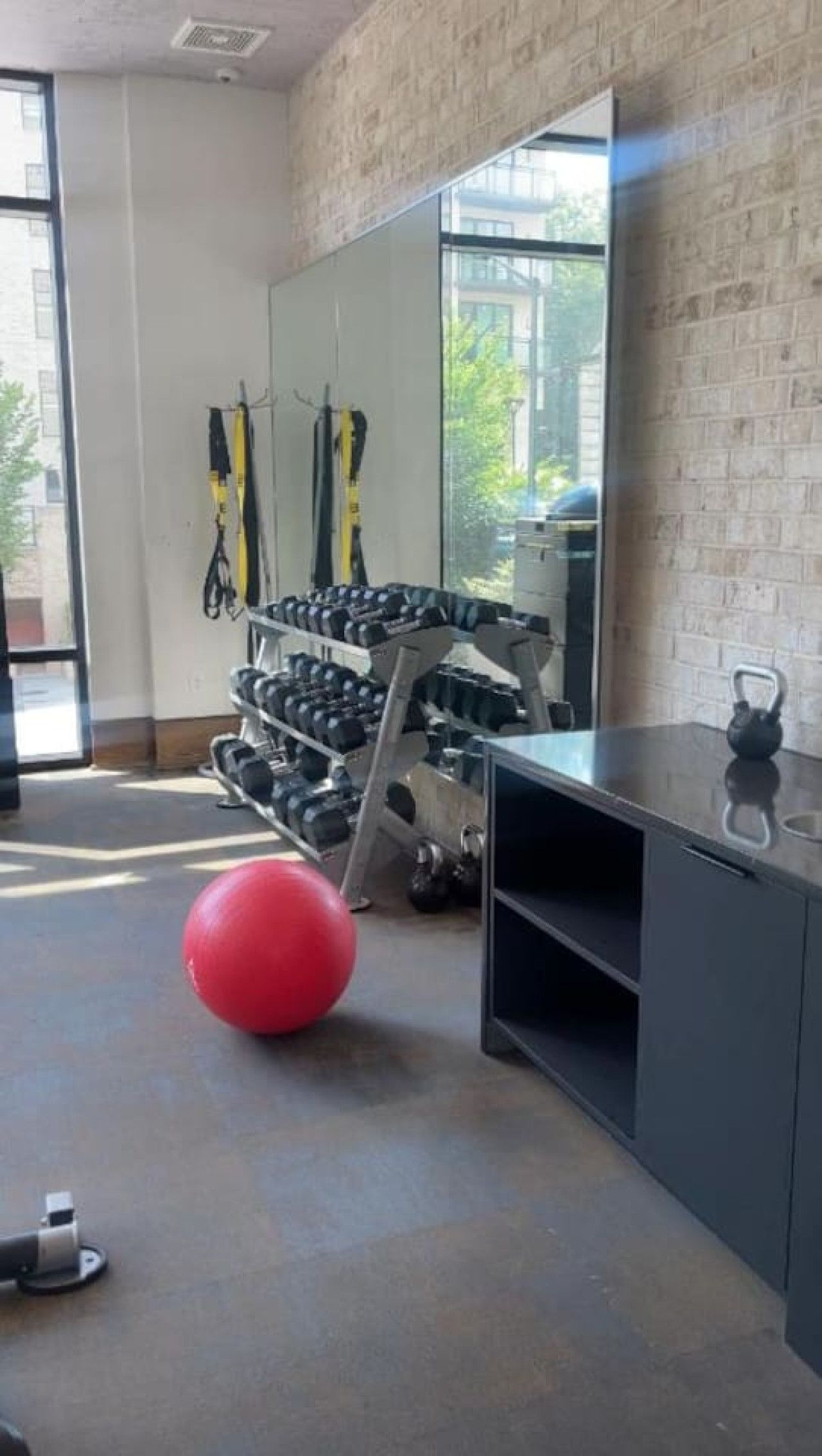 Een sportschool met trainingsapparatuur, een rode trainingsbal en een kettlebell.
