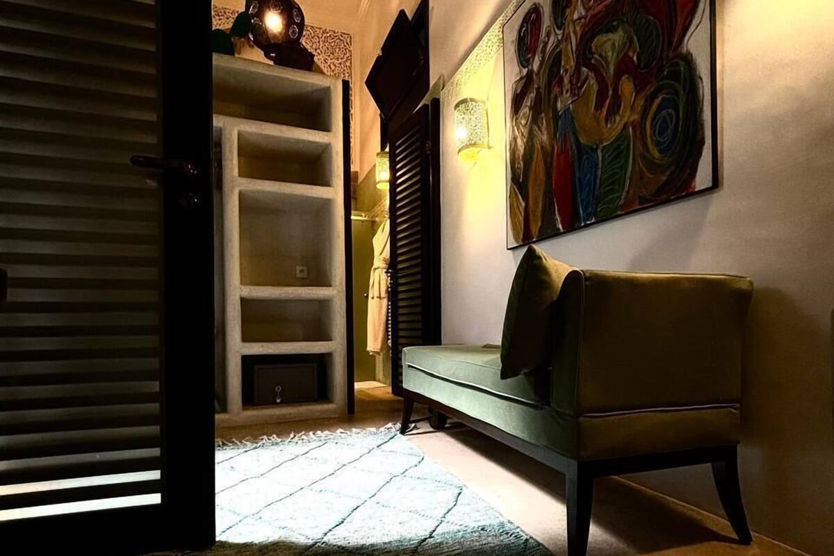 A cozy living area with a sofa, a colorful abstract painting, and a patterned rug.