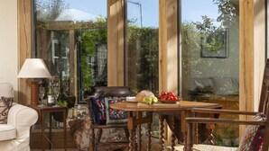 Una habitación acogedora con una mesa de madera dispuesta para una comida, una silla cómoda y un sofá.