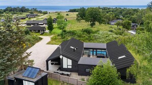 Una casa moderna con una terraza amplia y vista al mar.