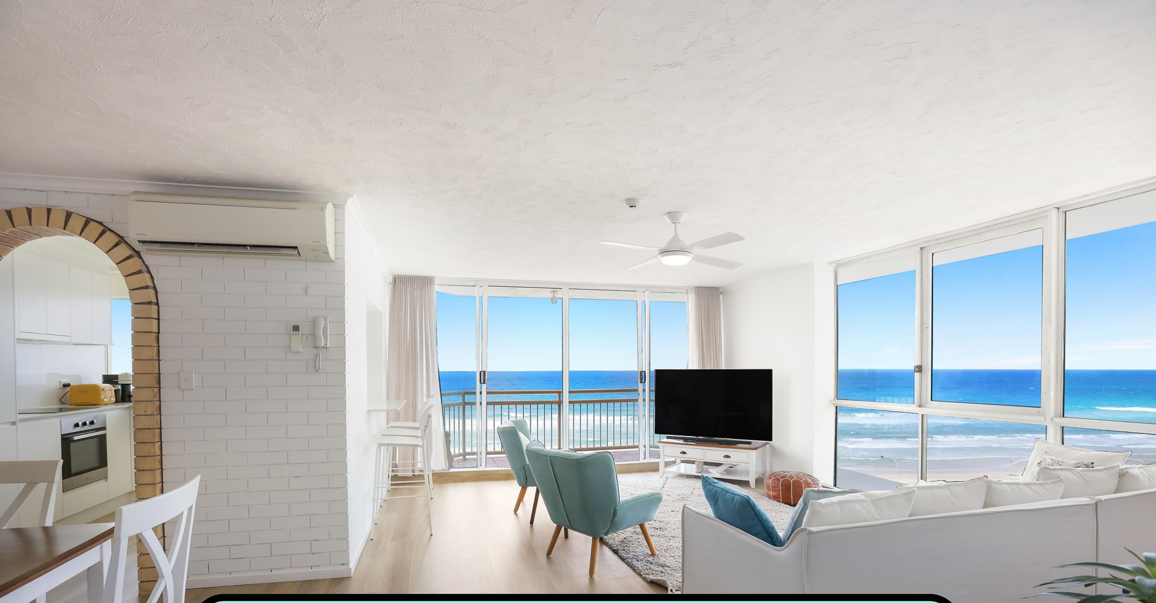 A spacious 2-bedroom apartment with a balcony, a living area with a TV, and a kitchen. It includes a 1-car space, 2 bathrooms, and is 108 square meters in size. Amenities include smart TV, Wi-Fi, and Foxtel 4K.