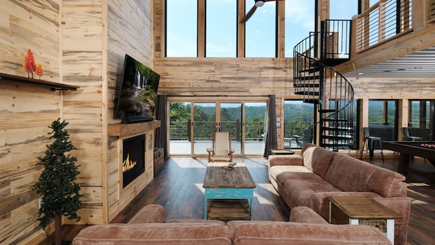 Un amplio salón con chimenea, un sofá grande y techo de madera.