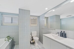 A modern bathroom with a toilet, sink, and mirror. - Rainbow Pacific Ocean Views (Coolangatta)
