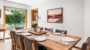 Comedor con una mesa de madera dispuesta para seis personas, rodeada de sillas.