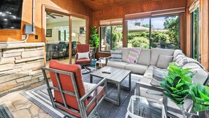 Una sala de estar acogedora con chimenea de piedra, un sofá cómodo y un comedor con mesa y sillas.