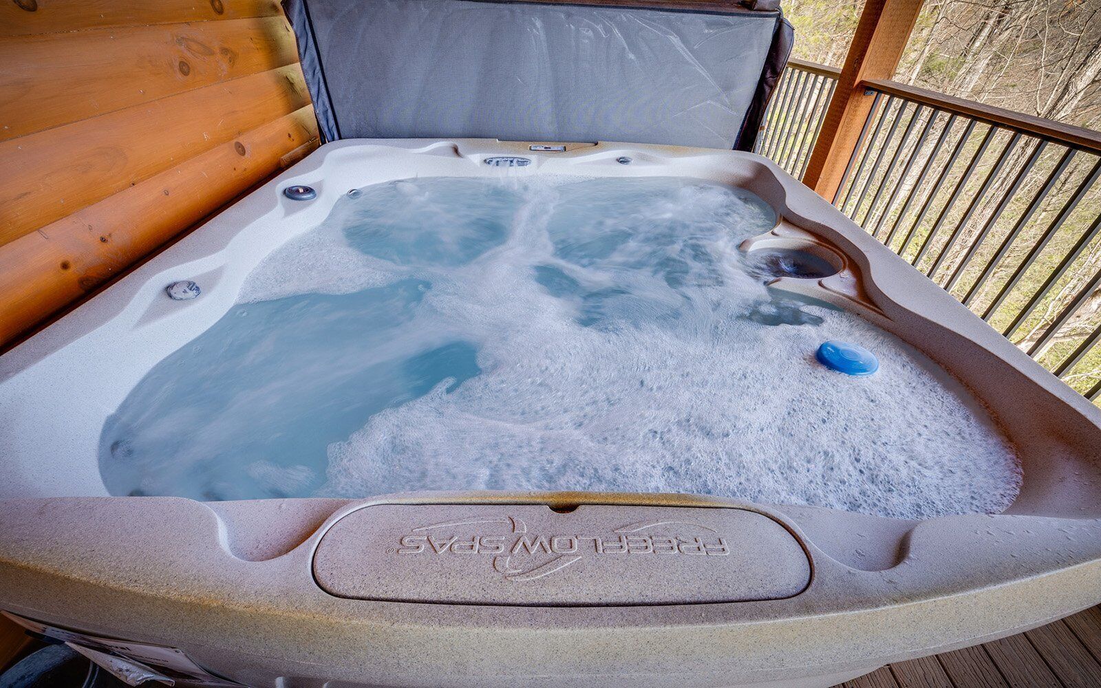 Ein Whirlpool mit Holzterrasse und Metallgeländer.