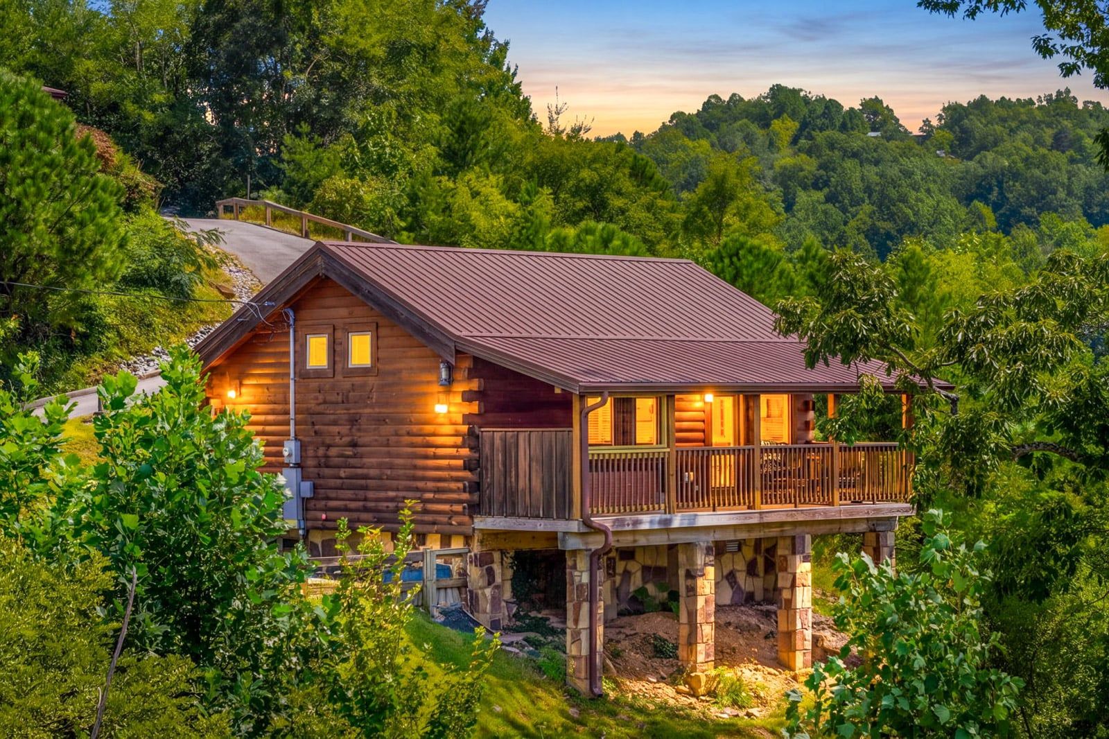 Eine Blockhütte mit Balkon, umgeben von dichtem Wald.