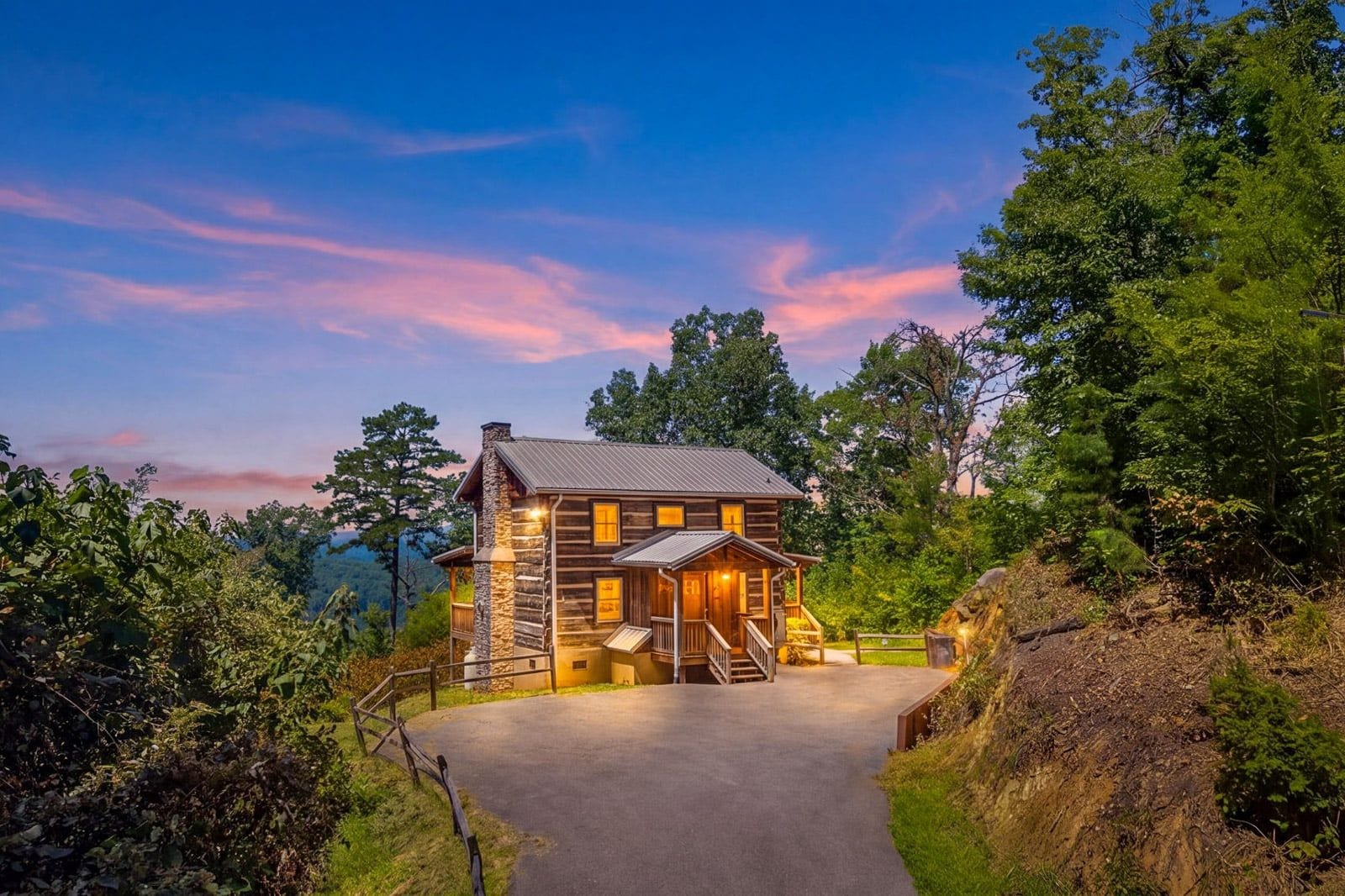 Une cabane en rondins avec un porche et une allée menant à l’entrée.