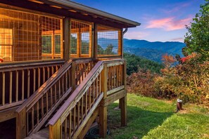 Une terrasse en bois avec un escalier menant à un espace abrité doté de fenêtres.