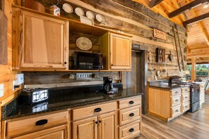 A rustic kitchen with wooden cabinets, a coffee station, and a sign indicating dairy and milk-cream products. - The Homestead & The Shed - 2 side-by-side cabins! (Gatlinburg)