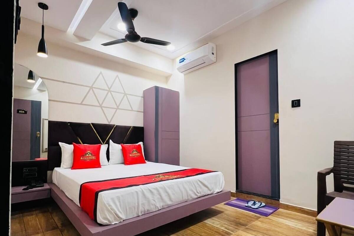 A modern hotel room with a bed, bedside tables, a desk, and a chair.
