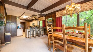 Un interior rústico de madera con comedor, cocina y barra.