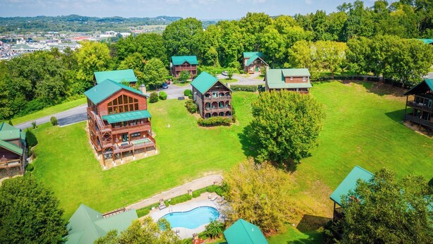 Eine Lodge mit mehreren Gebäuden, einem Schwimmbad und einer üppigen grünen Landschaft.