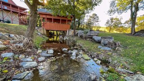 A wooden bridge over a stream, surrounded by rocks and trees.