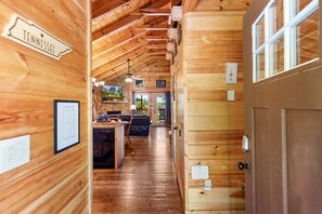 Un intérieur en bois agrémenté d’une enseigne du Tennessee, un coin repas et une vue sur l’extérieur.