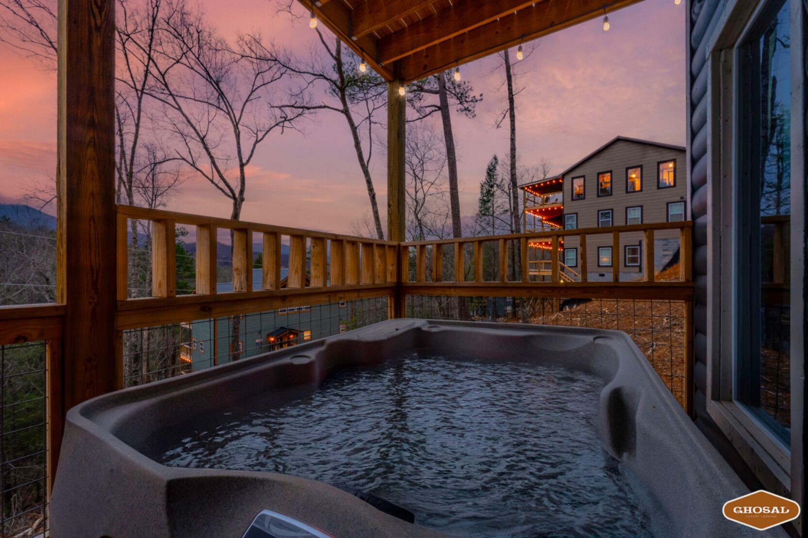 A hot tub on a wooden deck with a view of a house and trees.