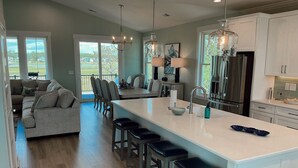 A spacious kitchen with a large island, modern appliances, and a view to the outdoors. - NOW AVAILABLE BRAND-NEW! Private beach home with incredible views! (Ocean Isle Beach)