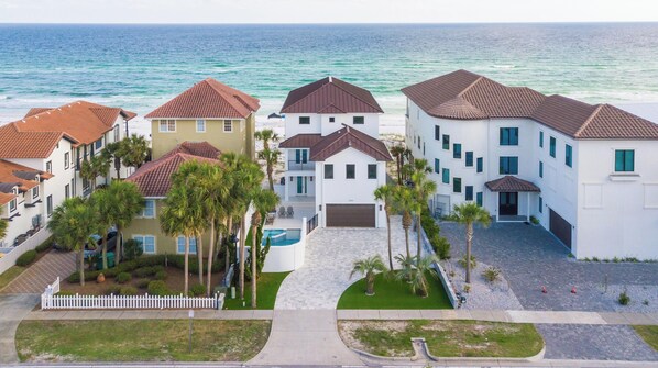 A coastal residential area with multiple two-story houses featuring red-tiled roofs and white walls.
