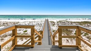 A wooden boardwalk leading to a beach with clear skies. - Luxurious Beachfront Retreat: Pool, Spa, Chefs Kitchen (Destin)