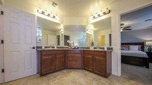 A corner bathroom with a vanity, double sink, and large mirrors. - Amazing 4 Bedroom 3 Bathroom Complete House (Tucson)