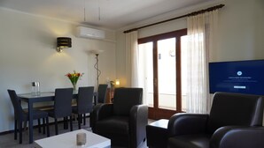 Un salon moderne comprenant un coin repas, un téléviseur à écran plat et un ventilateur de plafond.