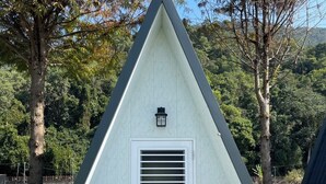 A triangular building with a white exterior and a small window at the top. - guantau (Puli)