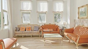 A spacious living room with two sofas, a coffee table, and large windows with curtains. - guantau (Puli)