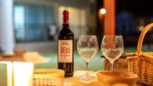 A bottle of Moulin de Gassac wine, two glasses, and a wicker basket on a table. - Taean Yeonpo Haibada Pension (Taean)